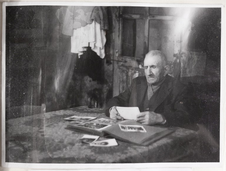 Gattatico-Reggio Emilia, 27-30 marzo 1970, Funerali di Alcide Cervi, Alcide Cervi seduto al tavolo nella sua casa con le foto dei figli